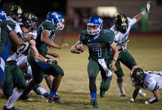 Gators quarterback Christian Lopez scrambles out of a collapsing pocket as a play breaks down during a game against the Basha Bears at Green Valley High School on Friday night.